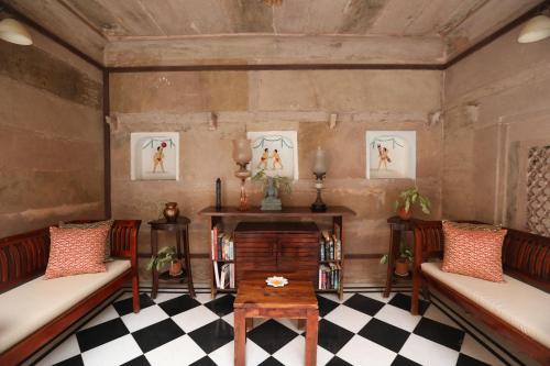 a living room with two benches and a fireplace at Guleria Kothi at Ganges in Varanasi