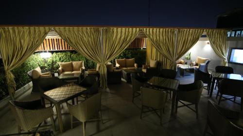 a restaurant with chairs and tables and curtains at Hotel City Heart Premium in Chandīgarh