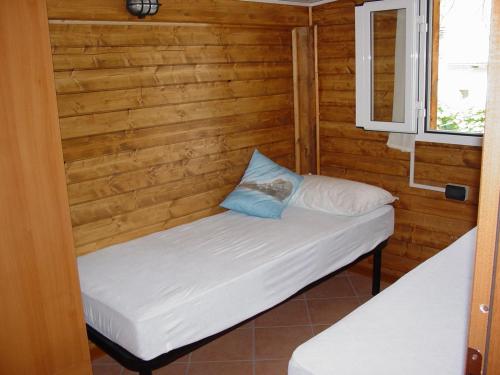 マリーナ・ディ・マッサにあるCamping Luniのベッドと窓が備わる小さな客室です。