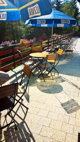 a group of tables and chairs with umbrellas at Osrodek Wypoczynkowy " BIESZCZADY" in Myczkowce