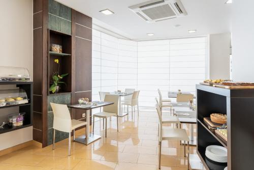 a restaurant with tables and chairs in a room at Exe Puerta San Pedro in Lugo