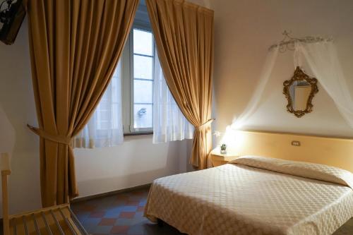 a bedroom with a bed and a window at Piccolo Hotel Etruria in Siena