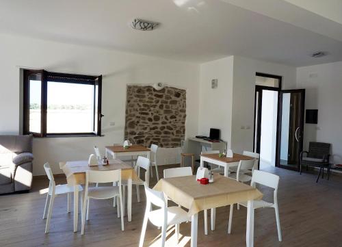 a dining room with wooden tables and white chairs at Il Sogno di Calipso in Amendolara