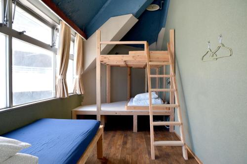 a bunk bed and a ladder in a room at Iruka Hostel in Toyama