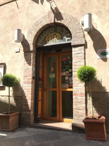 a door to a restaurant with a sign above it at Piccolo Hotel Etruria in Siena