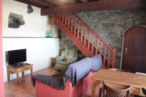 a living room with a staircase and a couch and a table at Can Bonada in El Serrat