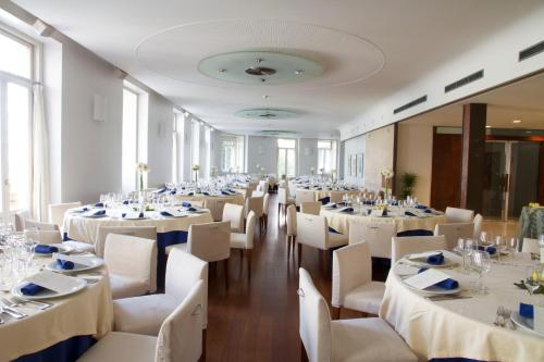 a banquet hall with white tables and white chairs at Gran Hotel Albacete in Albacete