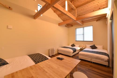 Cette chambre comprend 2 lits et une table. dans l'établissement Hinata-an, à Yufu