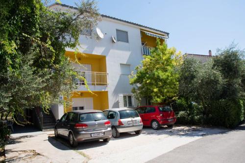 three cars parked in front of a building at Bora bora Apartment in Kaštela