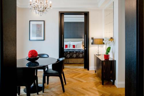 a room with a dining table and a bedroom at Hotel Schweizerhof Bern & Spa in Bern