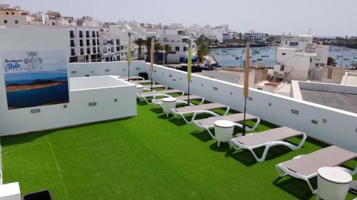 a row of chairs on a roof with green grass at Apartamentos Bello Lanzarote in Arrecife