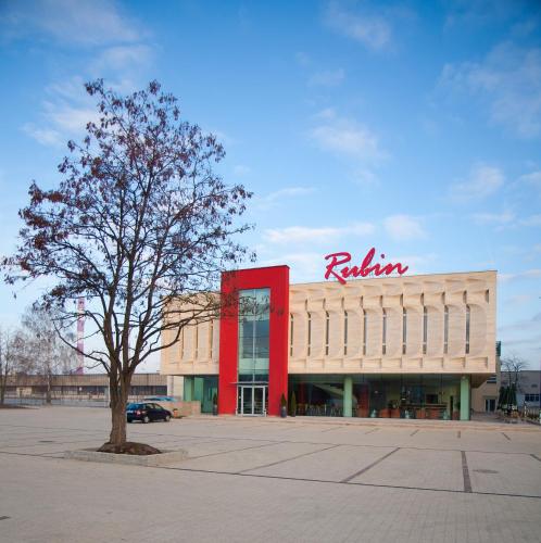 a building with a red sign on top of it at Hotel Rubin in Łódź