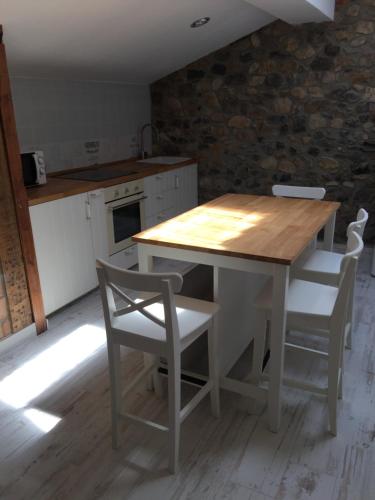 cocina con mesa de madera y sillas en pensionsanpelayo10, en Cangas de Onís