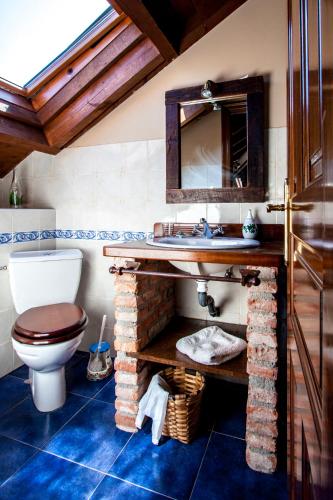 a bathroom with a sink and a toilet at El Búho de la Remolina in Bode