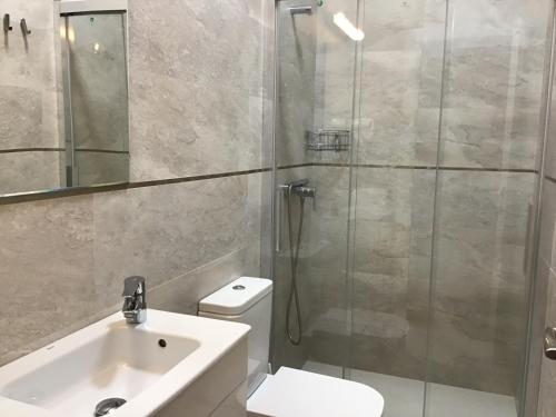 uma casa de banho com um chuveiro, um WC e um lavatório. em Apartamento Ribadesella em Ribadesella