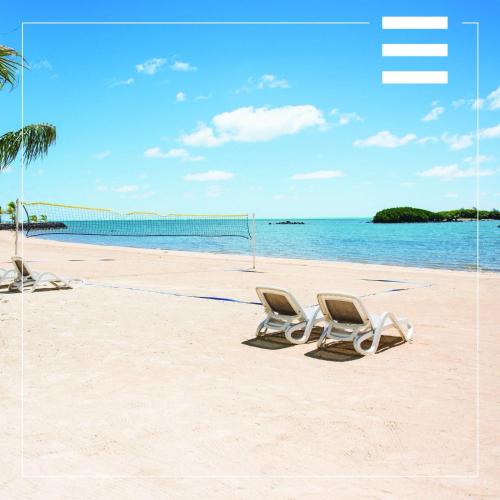 two chairs on a beach with the ocean at AZURI Serviced Garden Apartment in Roches Noires