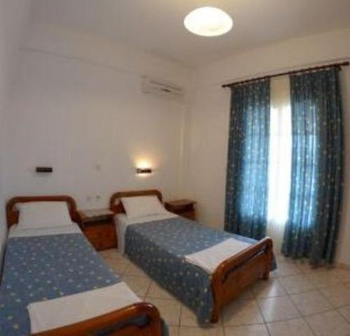 a bedroom with two beds and a window at Villa Leonidas in Agios Stefanos