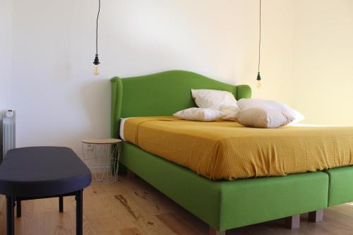 ヴァンデ・モンタリヴェにあるChambres d'Hôtes 1001 NUITS Montalivetの緑のベッド(枕2つ付)が備わる客室です。
