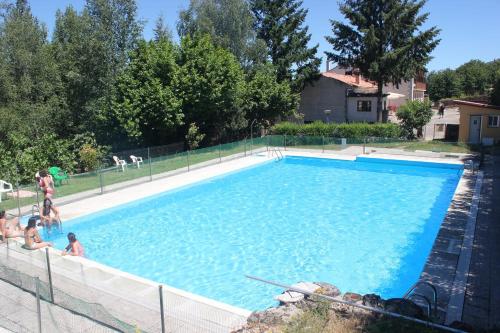 a large blue swimming pool with people in it at Hotel Cinco Castaños in Candelario