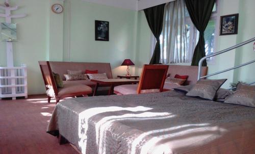 um quarto com uma cama, cadeiras e uma mesa em Misty Views- Susama Villa em Darjeeling