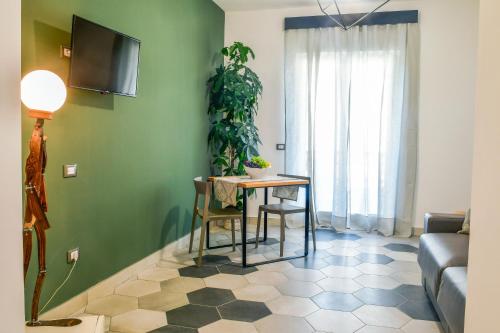a living room with a table and a green wall at Big Rose in Rossano