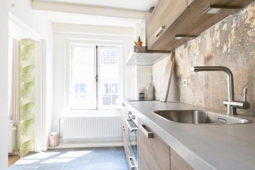 een keuken met een wastafel en een raam bij Fruit of the City - R.Q.C. in Den Haag