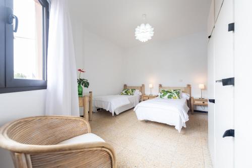 a white room with two beds and a chair at Los Murillos in Las Palmas de Gran Canaria