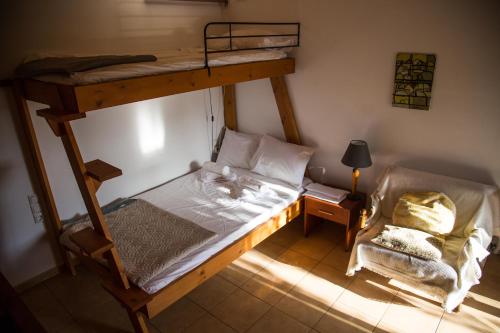 - une chambre avec des lits superposés et une chaise dans l'établissement Vrondos Apartments, à Faneroméni