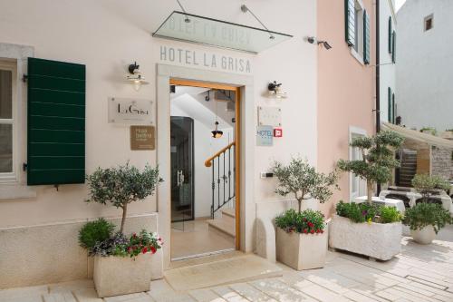 un hall d'hôtel avec des plantes en pot devant un bâtiment dans l'établissement Hotel La Grisa, à Bale