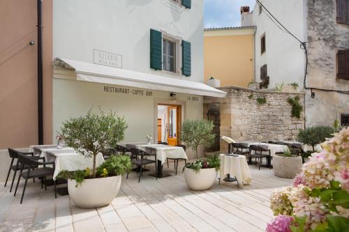 a patio with tables and chairs in front of a building at Hotel La Grisa in Bale