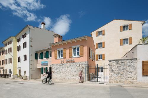 a man riding a bike in front of a building at Hotel La Grisa in Bale