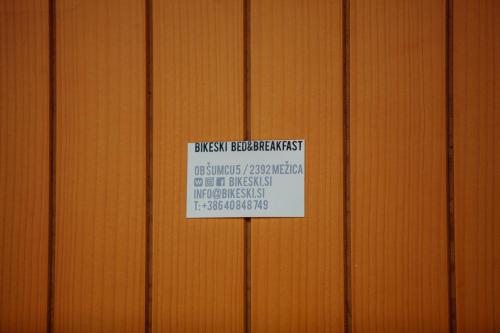 a sign on the side of a wooden wall at BikeSki family hotel, b&b, apartaments, rooms in Mežica
