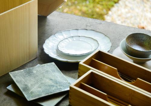 a table with plates and bowls on a table at Temple-stay WAQOO Mii-dera in Otsu