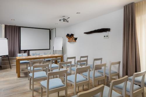 a room with chairs and a table and a screen at Hotel La Grisa in Bale
