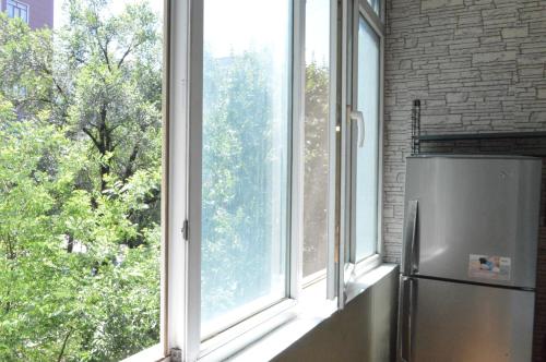 a kitchen with a window with a refrigerator in front of it at Apartment on Bokonbaev street, 145 in Bishkek