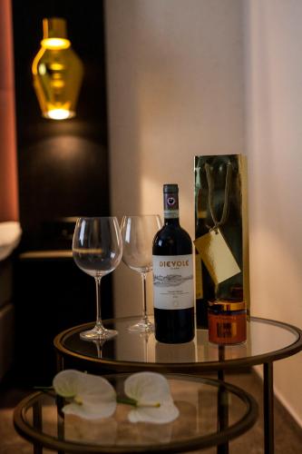 a bottle of wine and two glasses on a table at ONNO Boutique Hotel & Apartments in Rendsburg