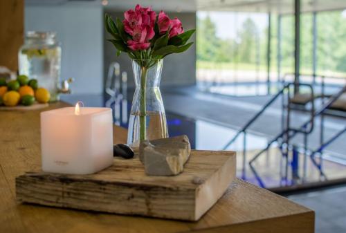 a candle and a vase of flowers on a table at ENDEMIT Boutique Hotel & Spa in Horní Bečva