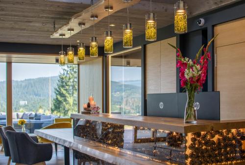 a dining room with a table with flowers and lights at ENDEMIT Boutique Hotel & Spa in Horní Bečva