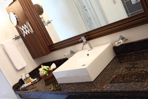 a bathroom with a white sink and a mirror at Surmeli Adana Hotel in Adana