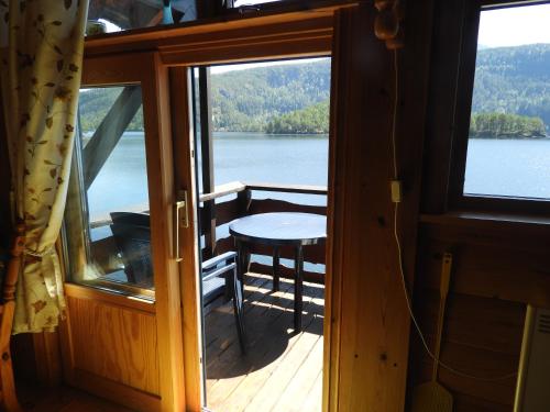 a balcony with a table and a view of a lake at Naustloftet in Hornindal