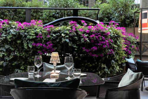 a table with wine glasses and flowers on a patio at Bianca Maria Palace Hotel in Milan