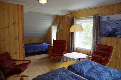 a bedroom with a bed and chairs and a window at Lunheim in Geiranger in Geiranger