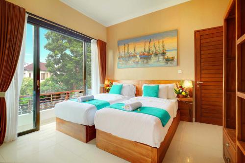 a bedroom with two beds and a large window at Villa Alessandra Seminyak By Bali Asia Villa in Seminyak