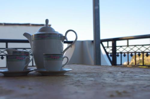 eine Teekanne und Tassen auf einem Tisch in der Unterkunft Limnes Home in Moutsoúna