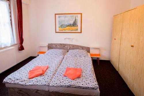 ヤーヒモフにあるApartmán K lanovceのベッドルーム1室(オレンジ色の枕2つ付)