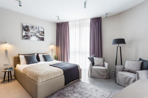 1 dormitorio con 1 cama y 1 silla en VISIONAPARTMENTS Route de Vallaire - contactless check-in, en Lausana