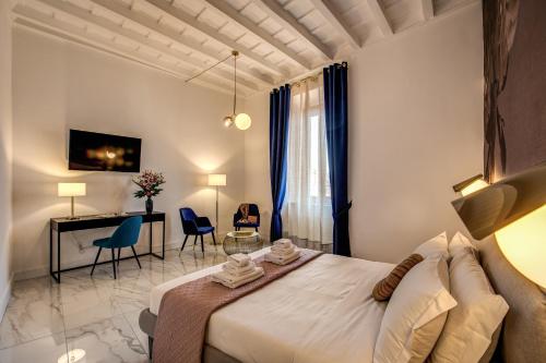a bedroom with a bed and a desk and chairs at Little Queen Pantheon in Rome