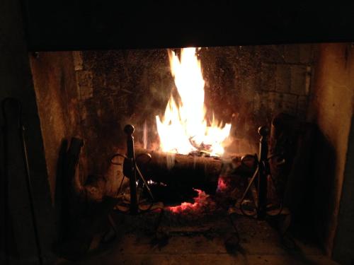 a fire in a stone fireplace with flames at Il Peschio in Pescocostanzo