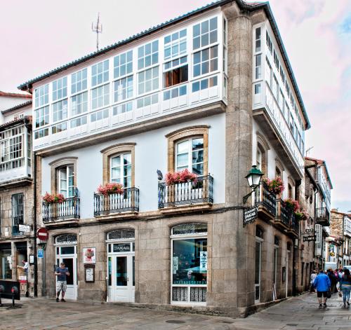 un edificio con un reloj frente a la Pension Or Codex en Santiago de Compostela