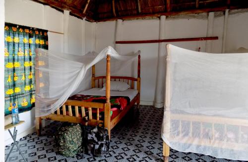 Schlafzimmer mit einem Bett mit Moskitonetz in der Unterkunft Kasenyi Lake Retreat & Campsite in Kasese